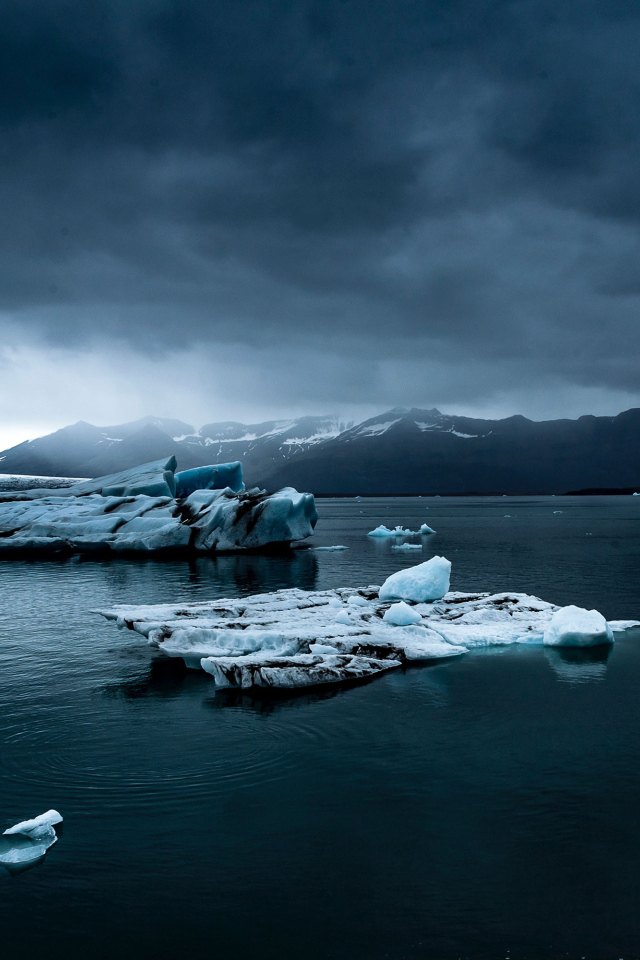 Большие голубые льдины в воде под пасмурным небом