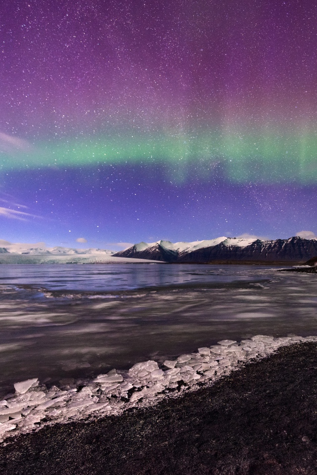 Северное сияние в небе над покрытым льдом озером 