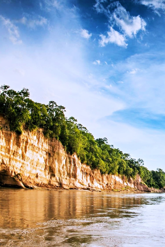 Скала на берегу реки под красивым небом