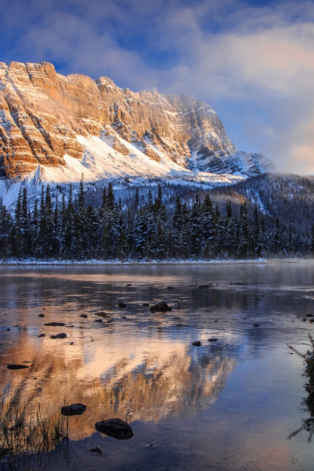 Покрытые снегом горы у заледеневшего озера