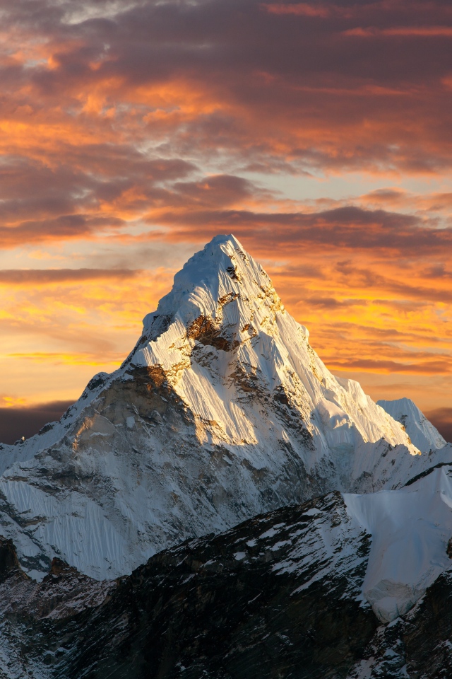 Заснеженная верхушка горы под красивым небом в лучах солнца 