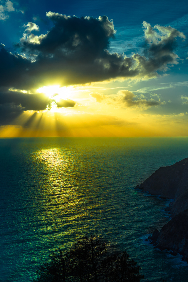 Лучи солнца пробиваются сквозь облака над океаном