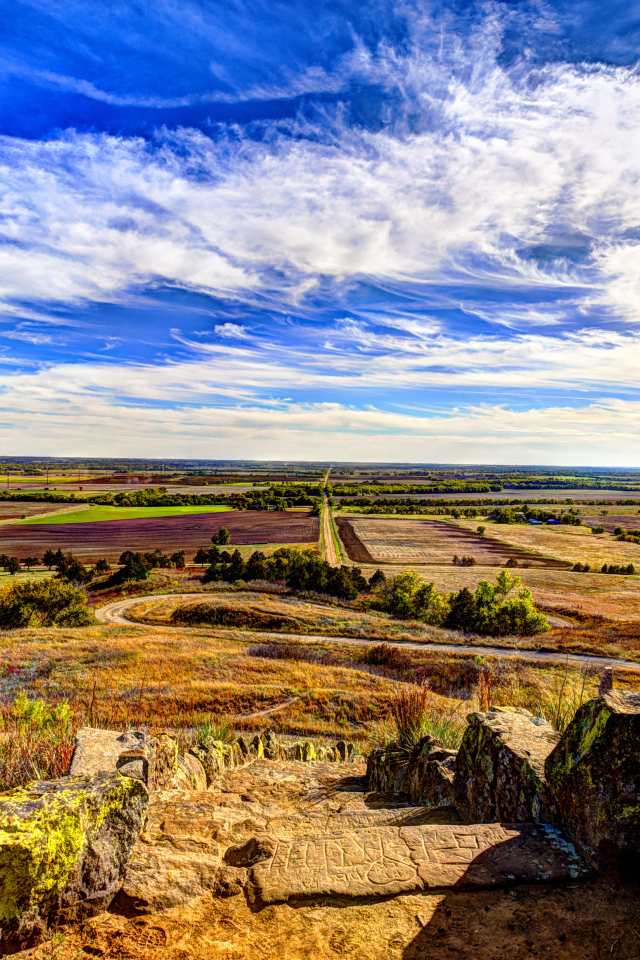 Вид на поле под красивым голубым небом с белыми облаками