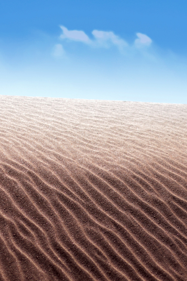 Песок в пустыне на фоне голубого неба