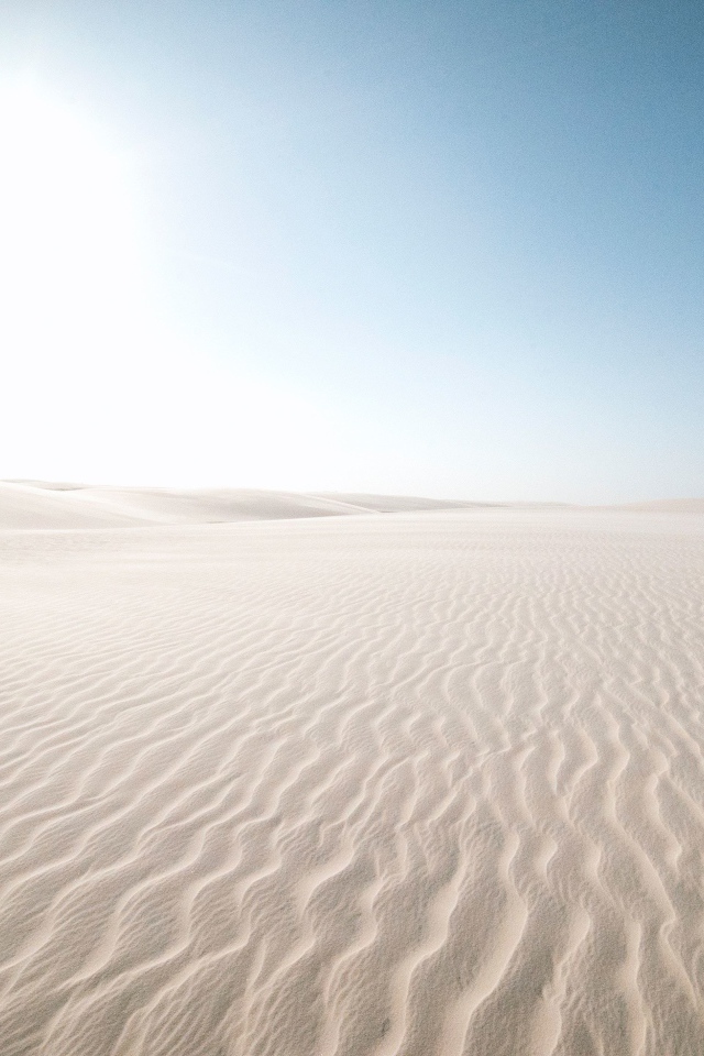 Белый песок в пустыне на фоне голубого неба