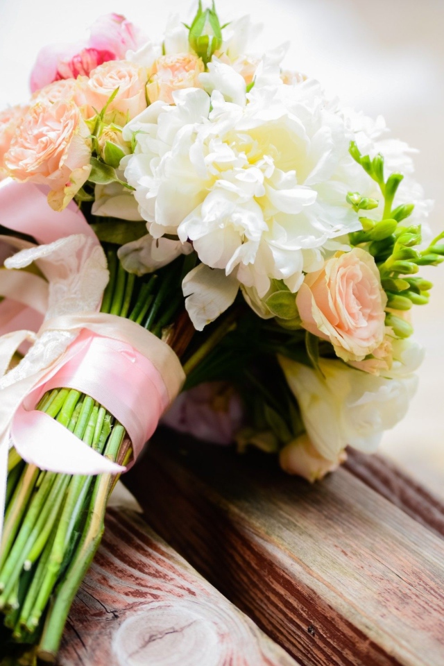 Красивый свадебный букет лежит на деревянной лавке