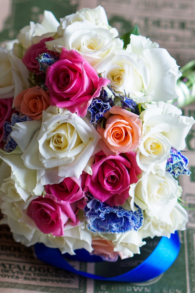 Красивый свадебный букет из роз лежит на газете