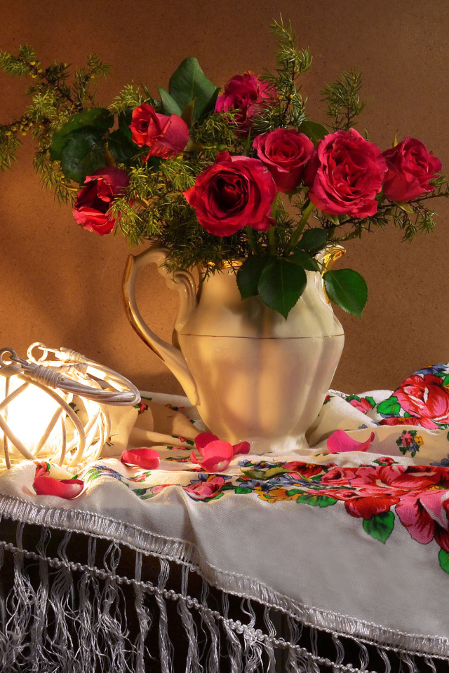 Букет роз в вазе на столе  с красивой скатертью 