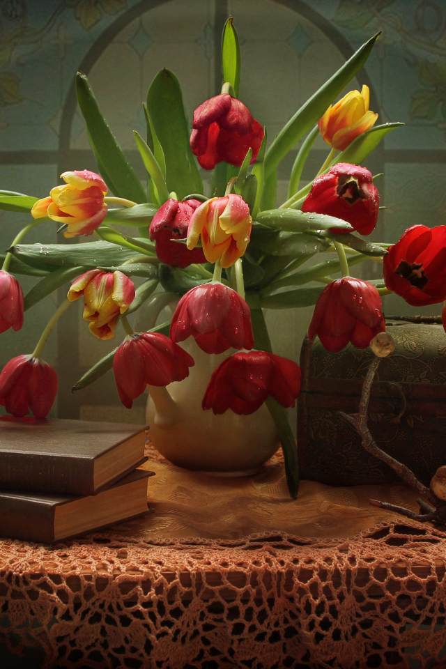 Букет тюльпанов на столе с книгами и шкатулкой