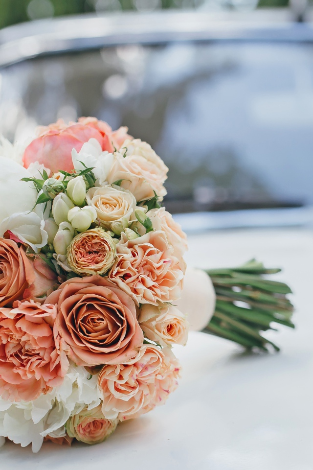 Свадебный букет роз лежит на машине