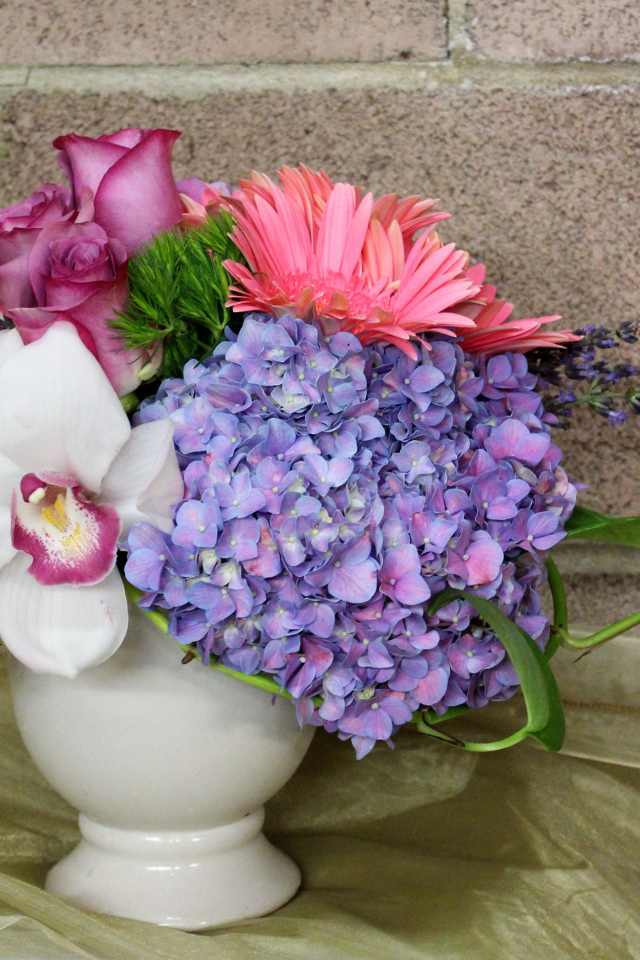 Красивый букет в белой вазе на фоне стены 