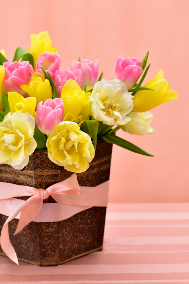 Букет красивых разноцветных тюльпанов в вазе на розовом фоне