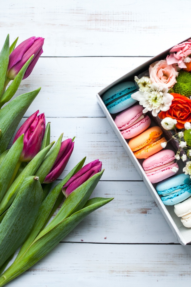 Букет сиреневых тюльпанов на столе с коробкой с макарунами