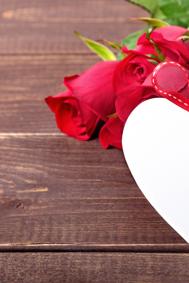 Букет розовых роз с бумажным сердцем на деревянном фоне