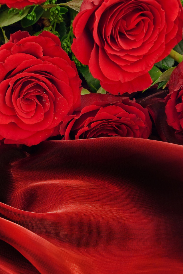 Bouquet of red roses on a red silk coverlet