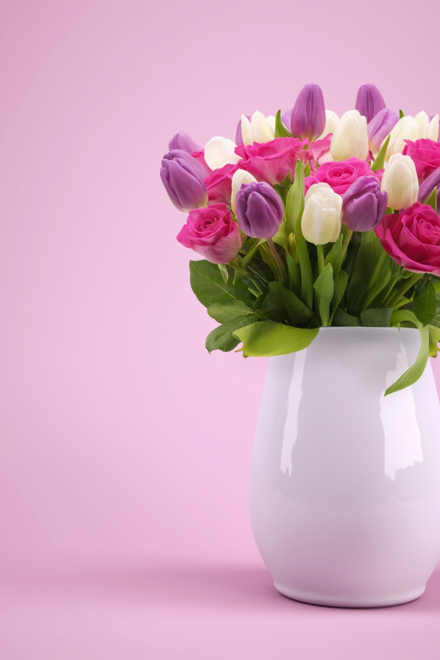 Букет тюльпанов и роз в белой вазе на розовом фоне