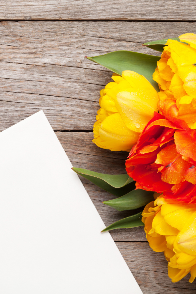 Букет желтых тюльпанов на столе с листом бумаги