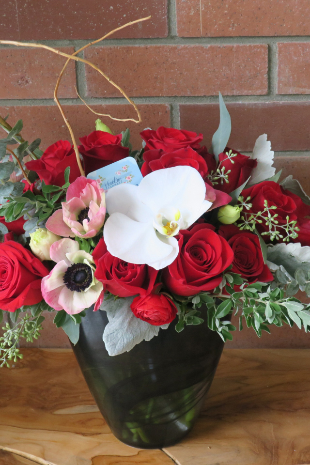 Букет с цветами анемоны, розы и орхидеи у стены 