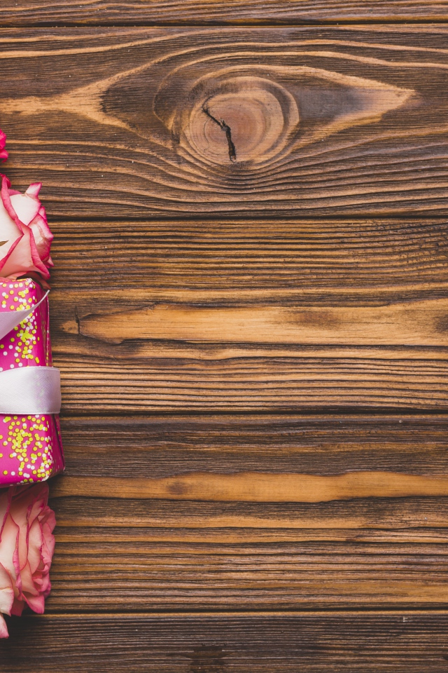 Подарочная коробка с букетом роз на деревянном фоне 