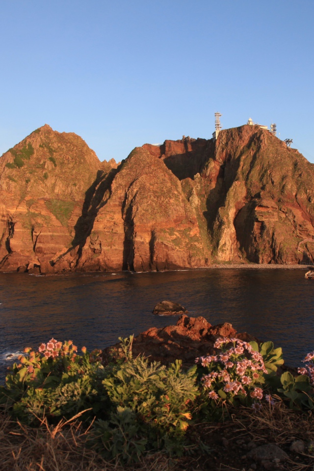 Скалистый остров в море под голубым небом