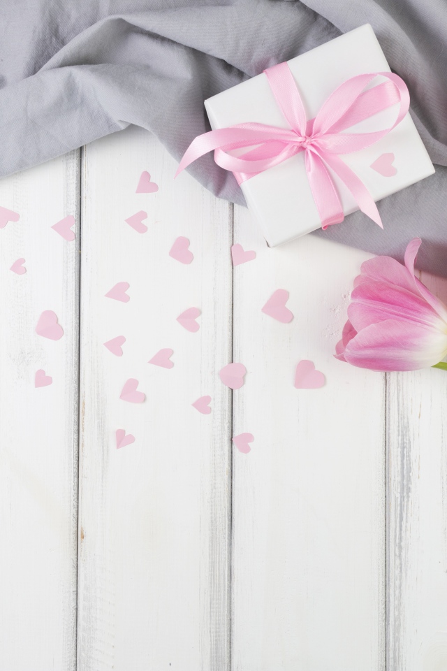 Три розовых тюльпана на столе с подарочной коробкой 