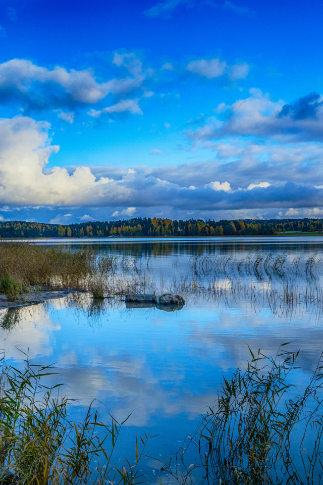 Голубое небо с облаками отражается в озере