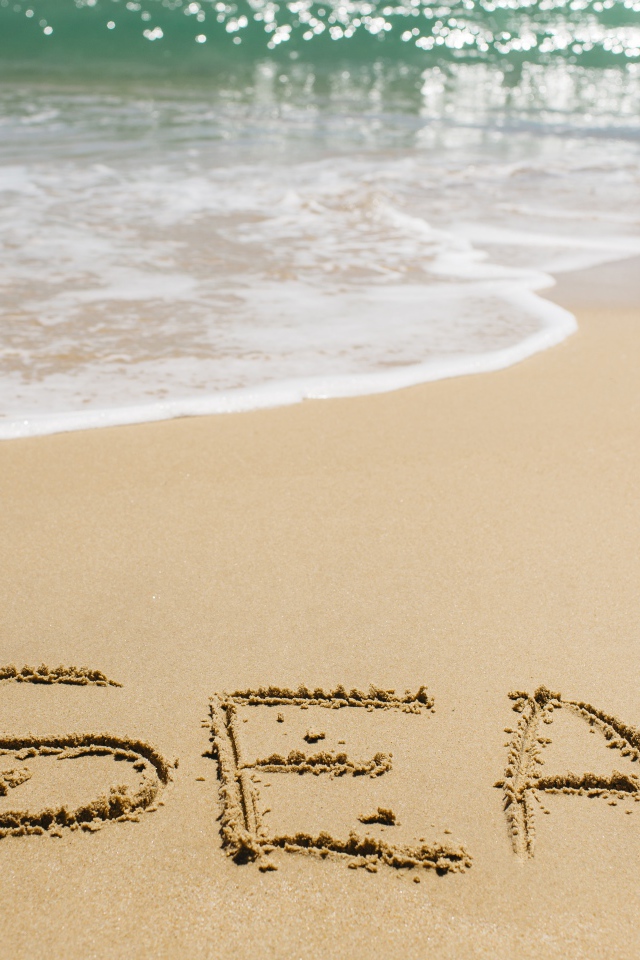 Надпись на песке у моря летом