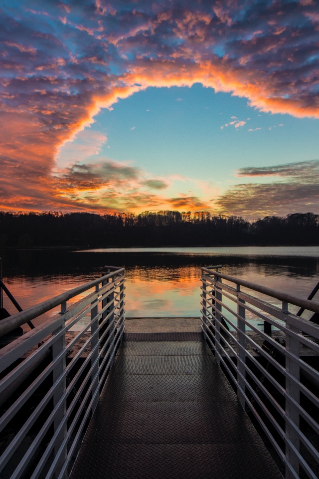Мост на озере на фоне красивого неба на закате