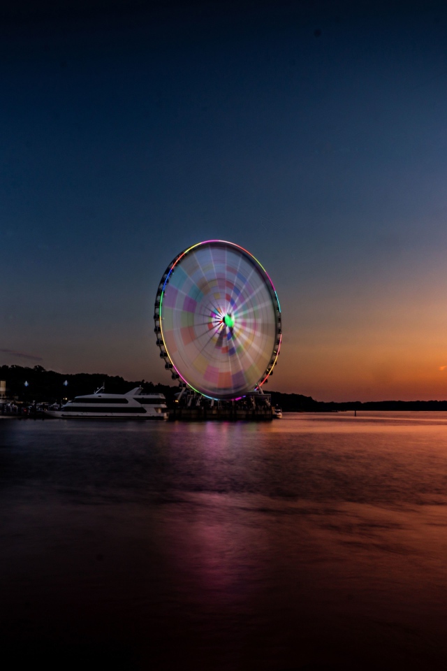 Колесо обозрения у воды на закате