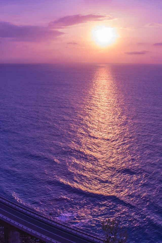 Фиолетовый закат солнца отражается в море 