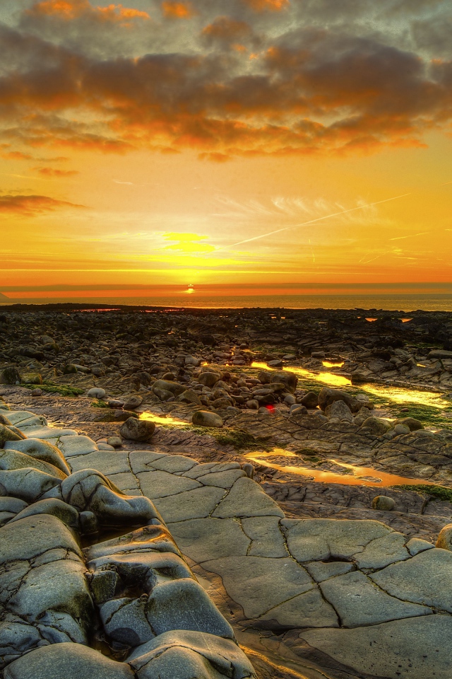 Каменный берег на фоне красивого неба на закате солнца