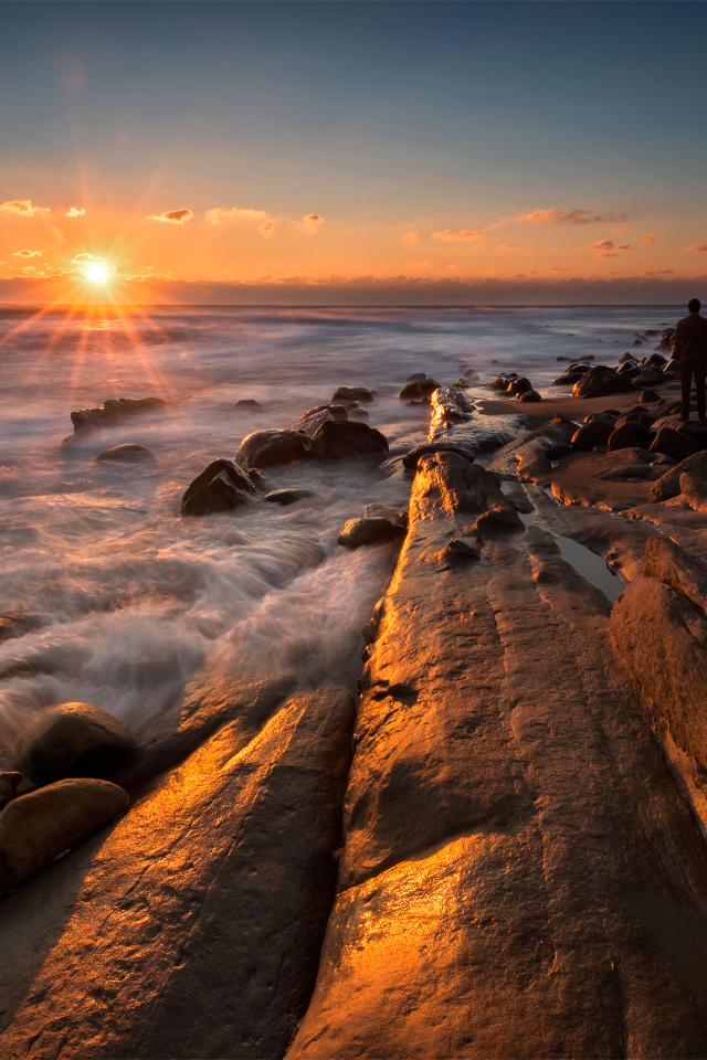 Каменный берег на морском побережье на закате солнца