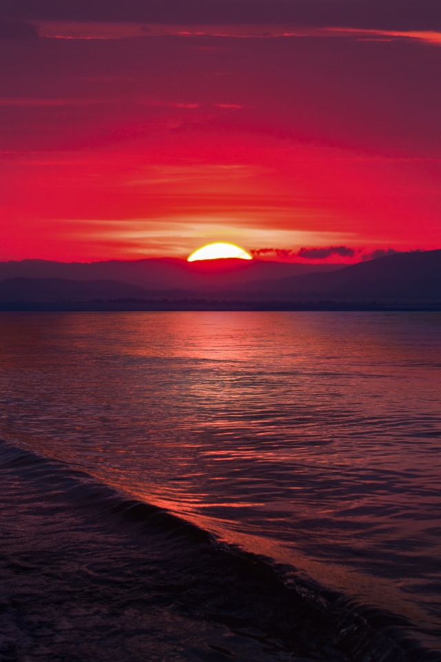 Закат красного солнца на морском горизонте 