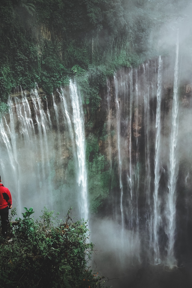 Человек смотрит на водопад сверху. 