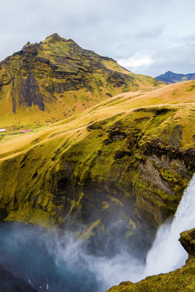 Водопад на фоне покрытых зеленью гор, Исландия