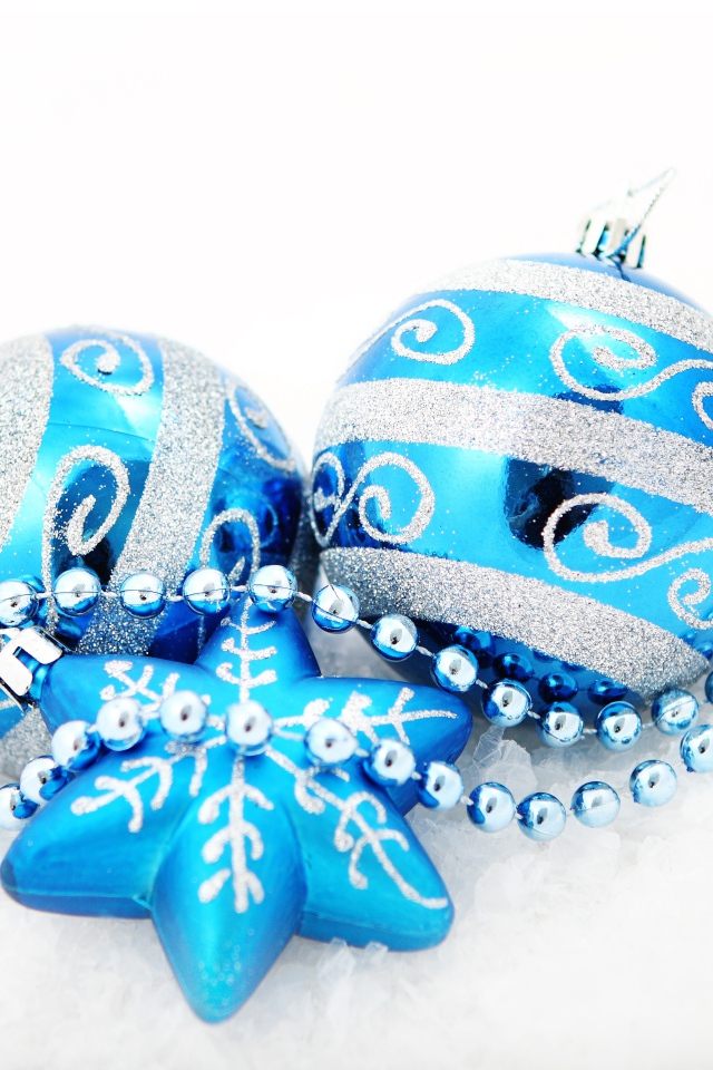 Красивые голубые елочные шарики со звездой и бусами на белом фоне