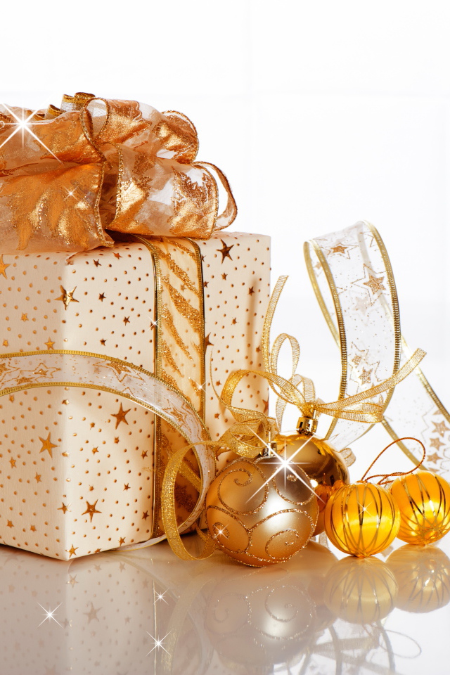 Красивый подарок с лентой и елочными шарами на белом фоне на Новый год 2019