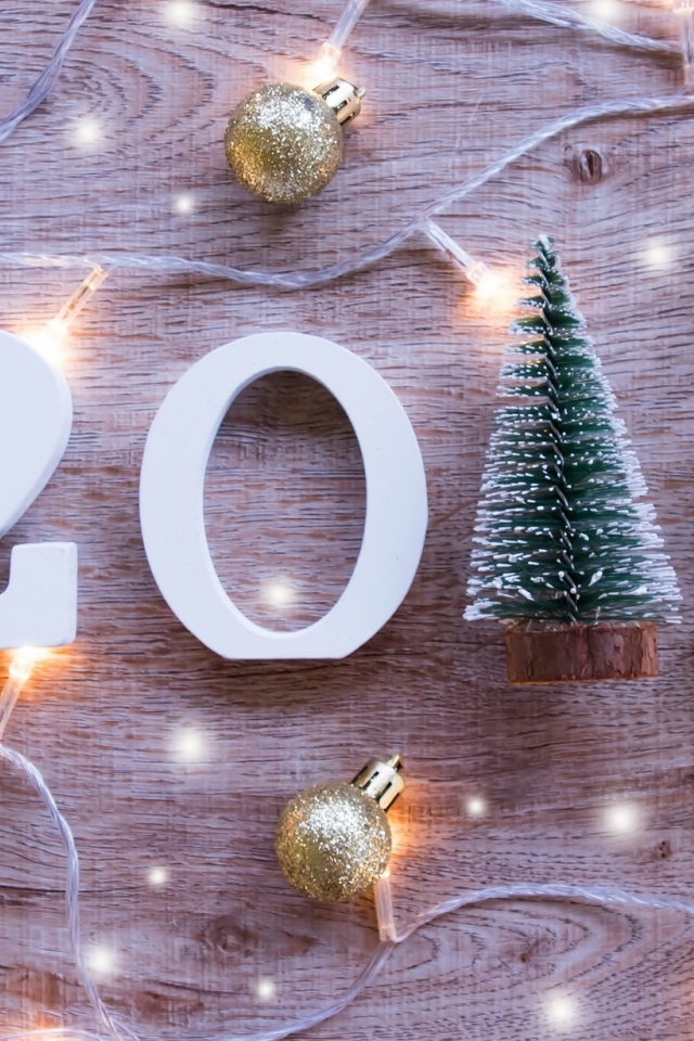 Цифры 2019 на деревянном фоне с елочными игрушками и гирляндой