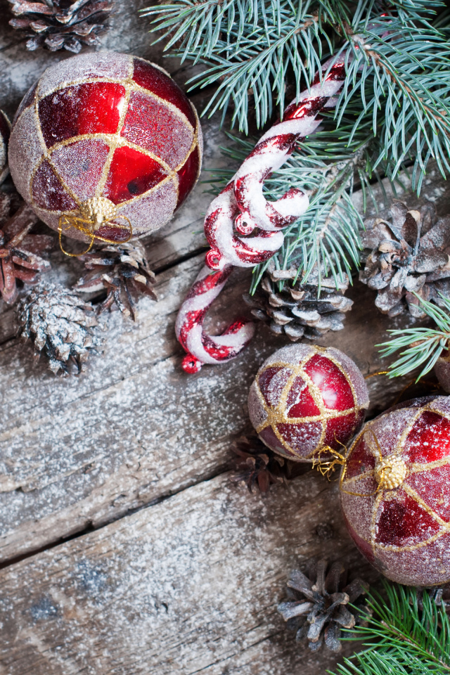 Красные еловые игрушки, шишки и зеленая еловая ветка на Новый год и Рождество 2019 