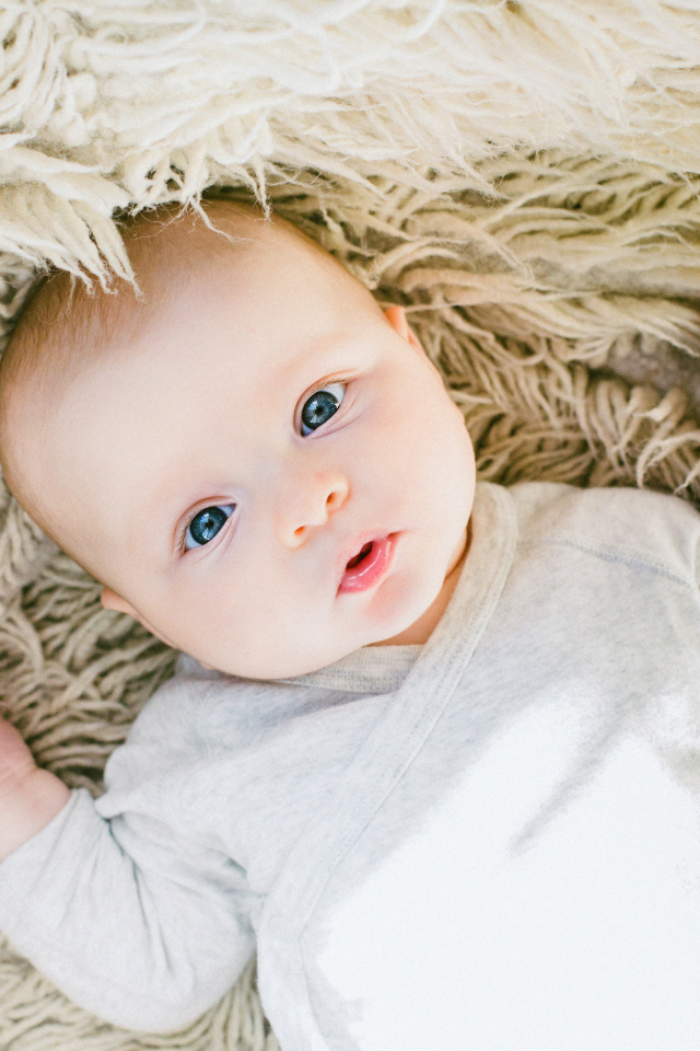 Милый младенец лежит на меховой накидке