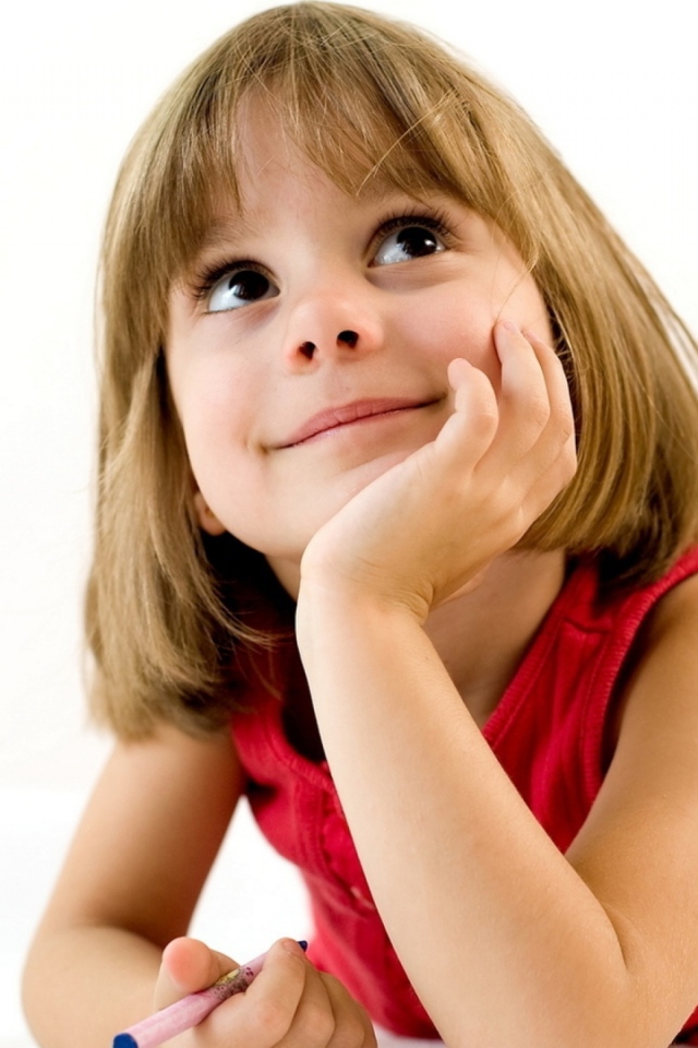 Милая девочка в красном платье рисует