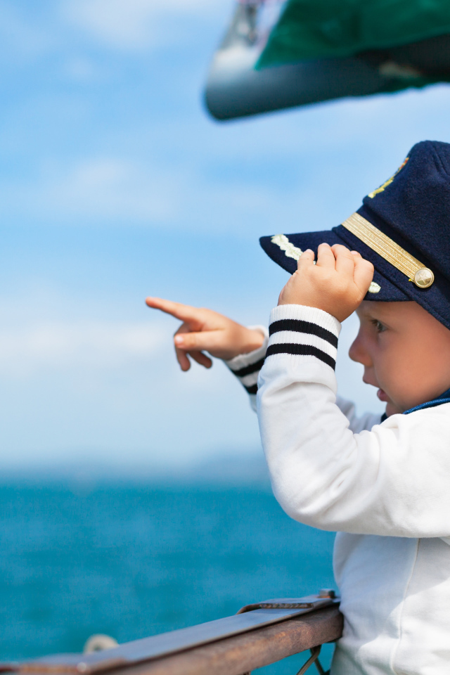 Маленький мальчик в форме капитана на корабле