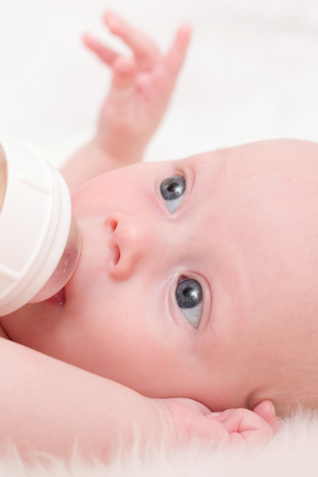 Новорожденного ребенка кормят с бутылки