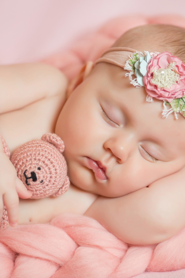 Спящая маленькая девочка с вязаным медвежонком в руке