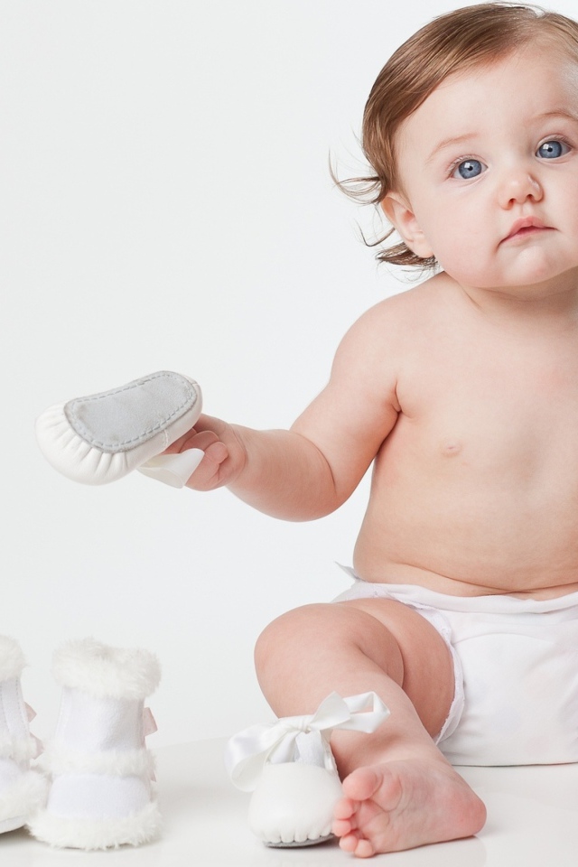 Маленький грудной ребенок с детской обувью