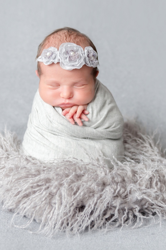 Маленький спящий младенец на сером фоне