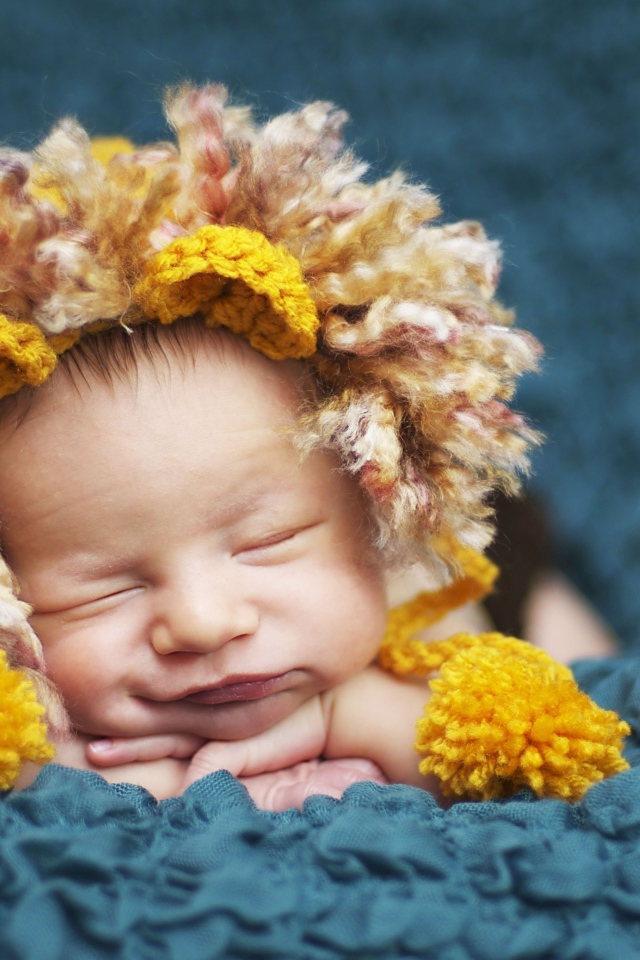 Милый спящий младенец в забавной шапке львенка