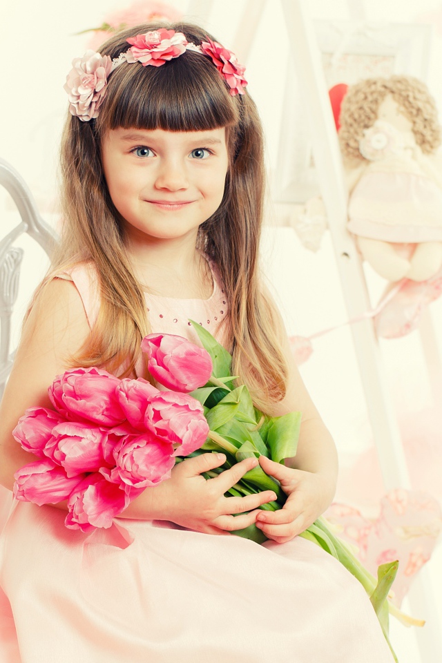 Красивая милая голубоглазая девочка с букетом розовых тюльпанов