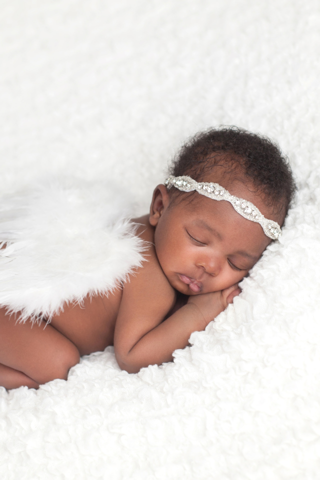 Темнокожий младенец спит с крыльями ангела