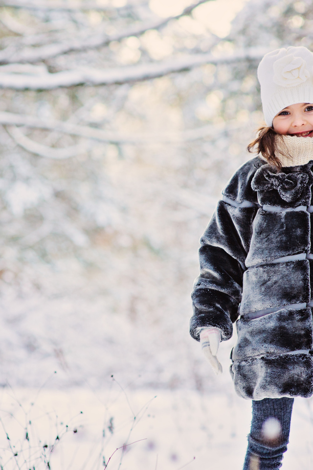 Милая маленькая девочка в шубе зимой